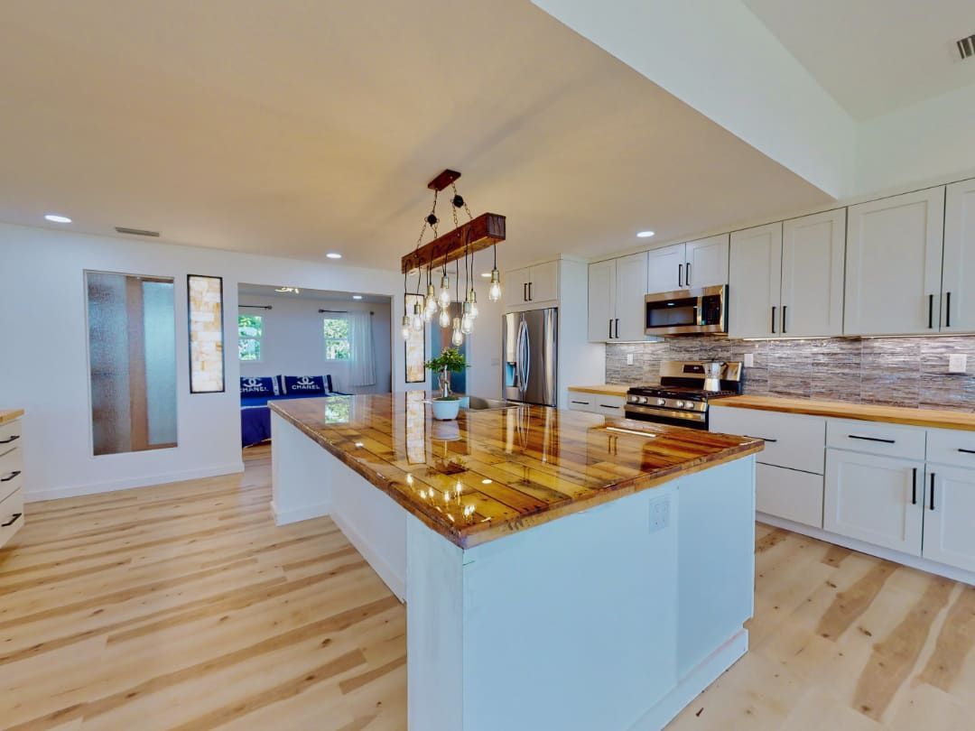 A kitchen with white cabinets and a large island in the middle.