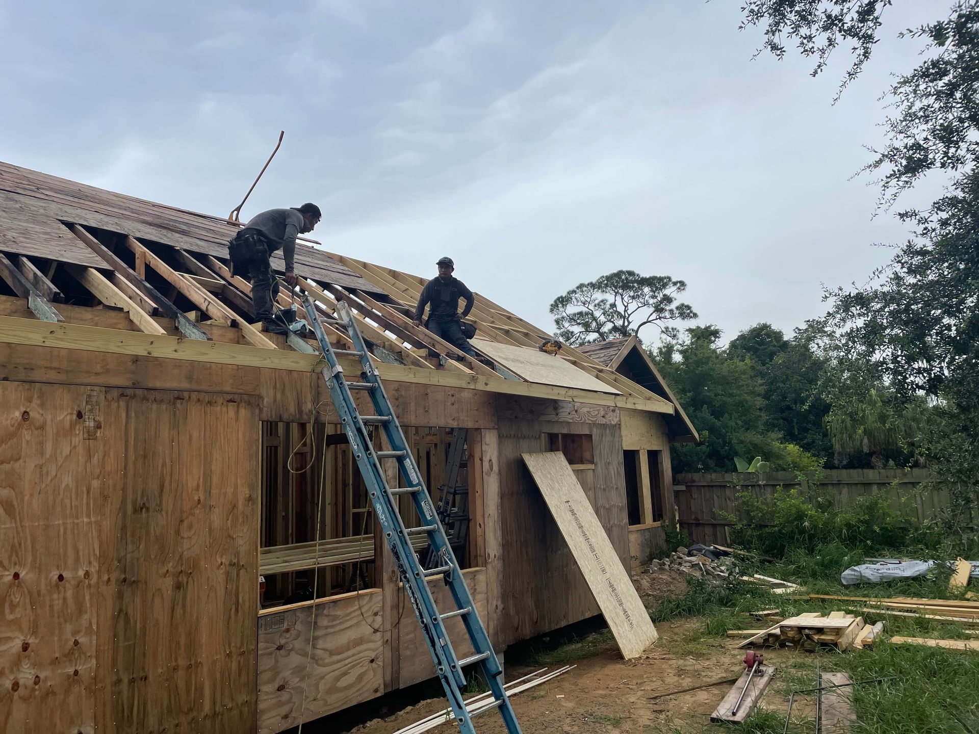 Two men are working on the roof of a house.
