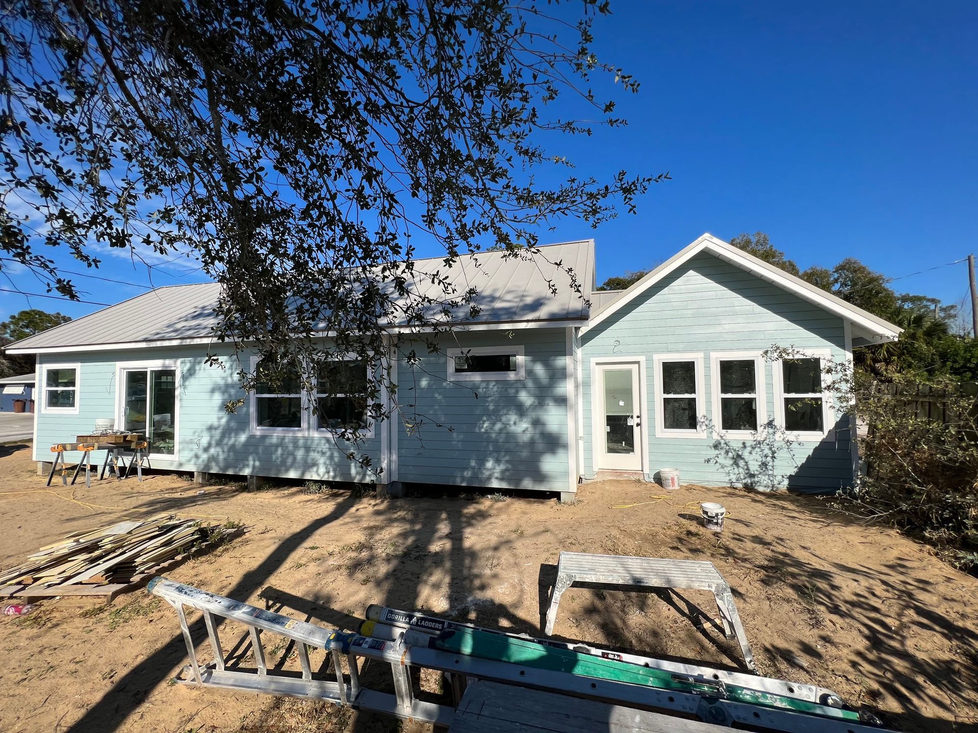 A house is being built in the middle of a dirt field.