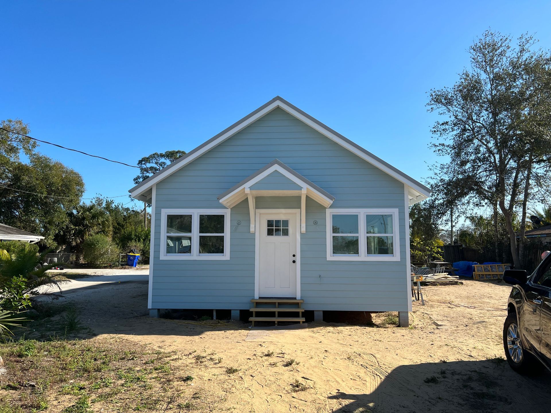 A small house with a car parked in front of it