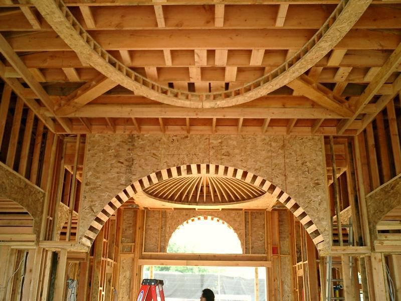 A man is standing in the middle of a building under construction.