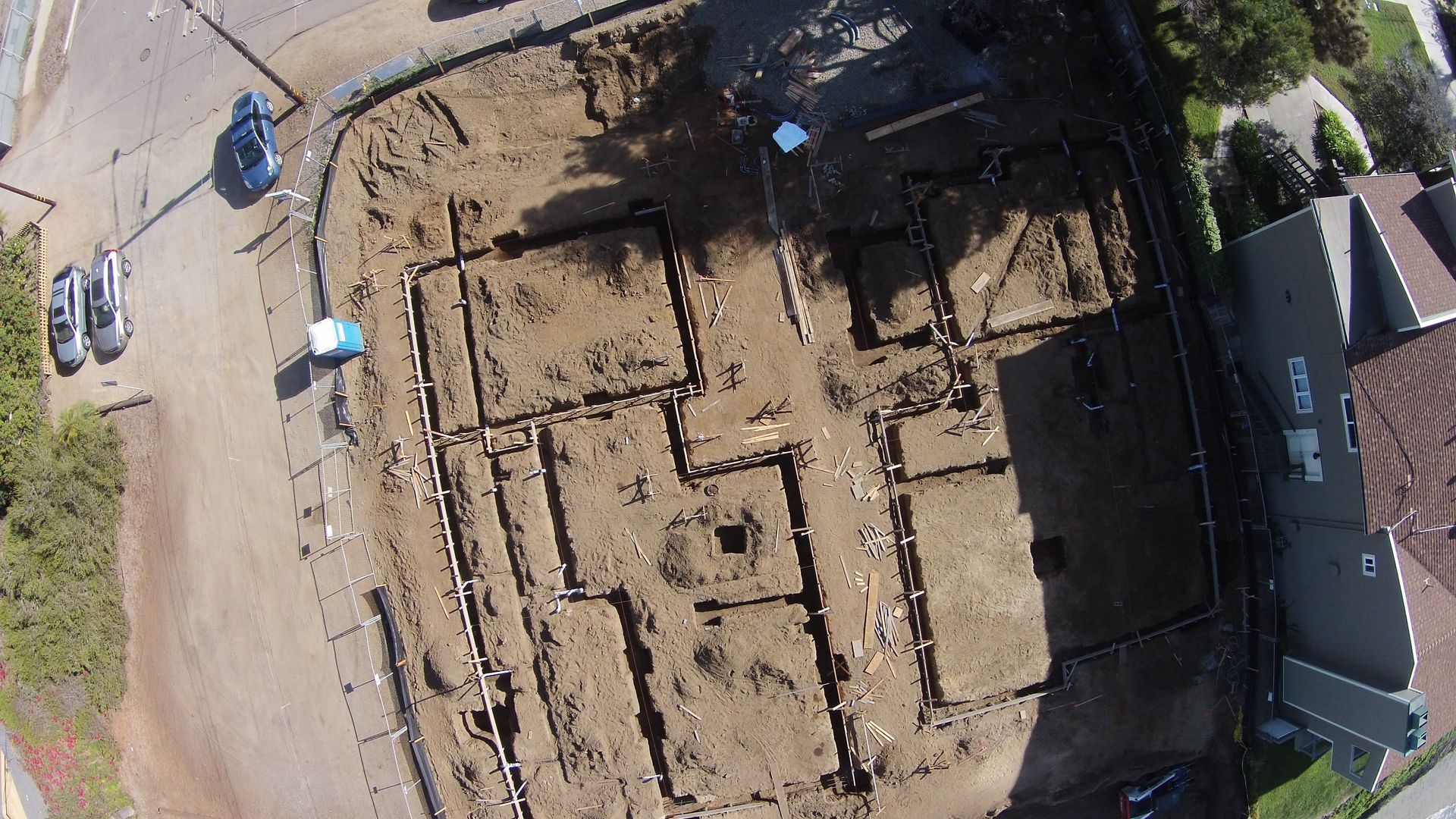 An aerial view of a construction site with a house in the background.