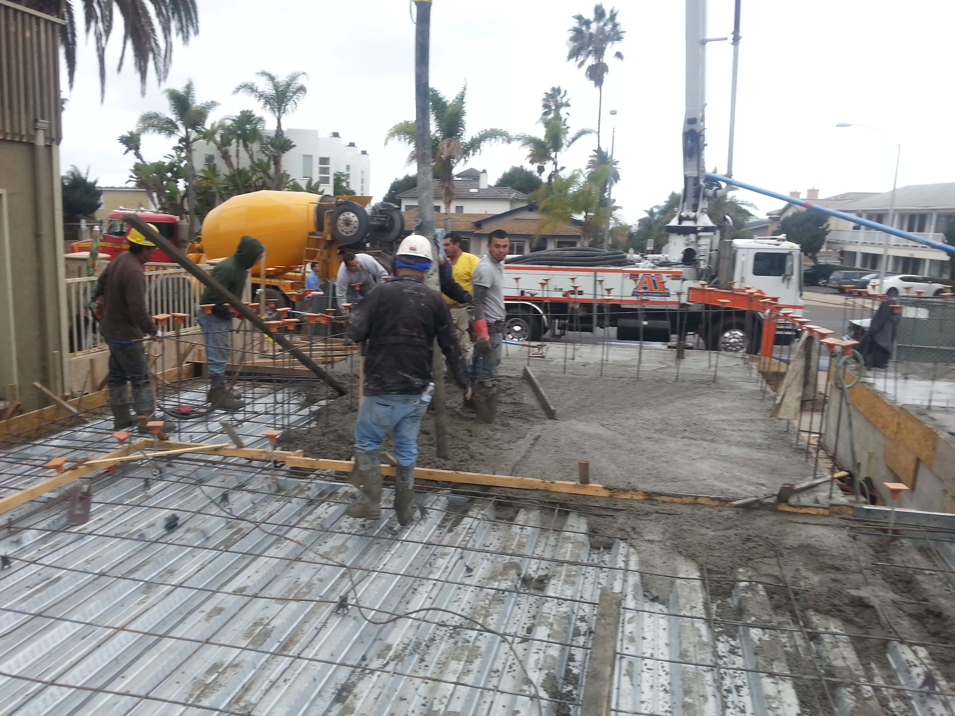 A group of construction workers are working on a concrete floor.