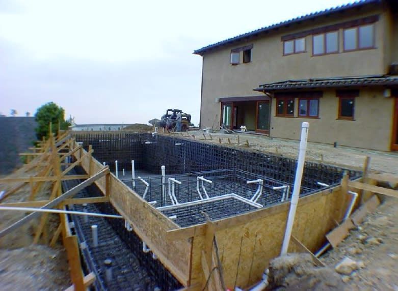 A swimming pool is being built in front of a house.