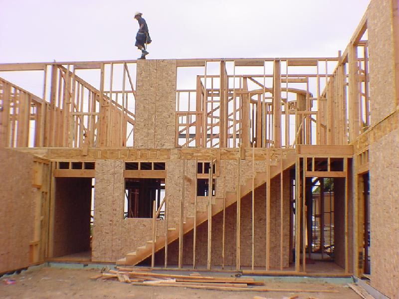 A man is standing on top of a building under construction.