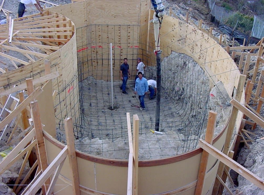 A construction site with palm trees in the background.