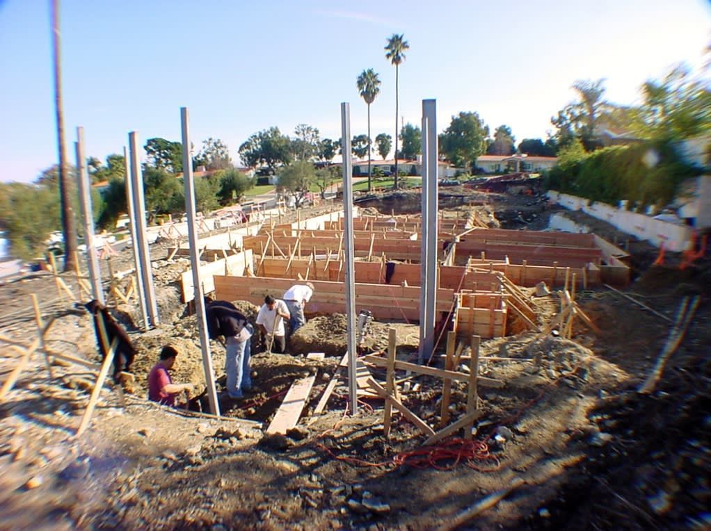 A construction site with palm trees in the background.