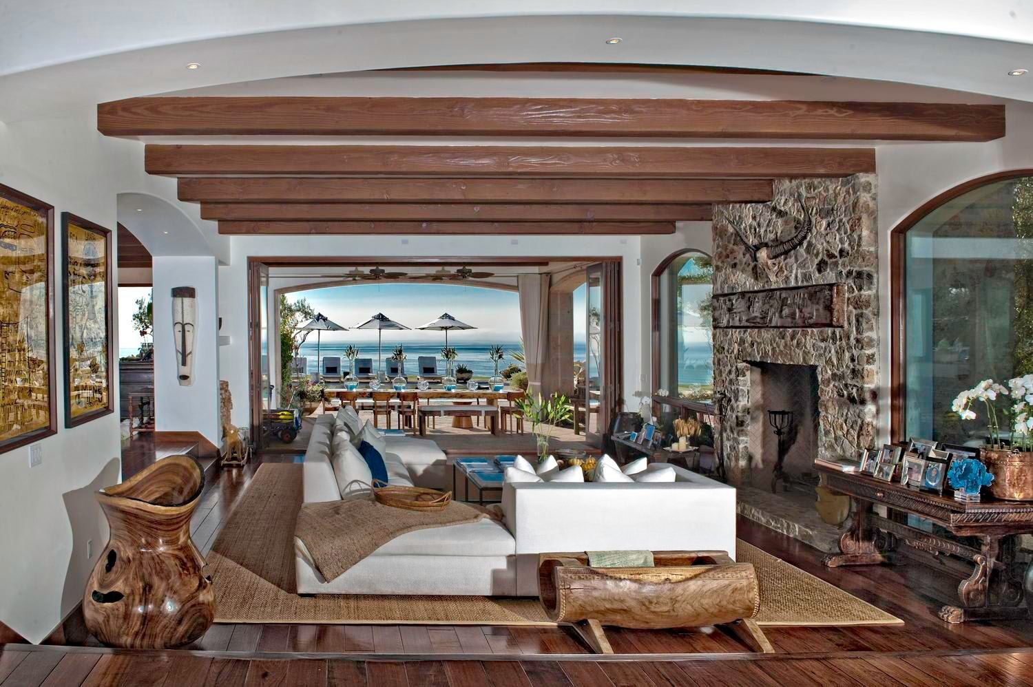 A living room with a fireplace and a view of the ocean.
