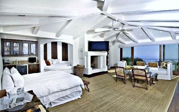 A large bedroom with a large bed and a fireplace.