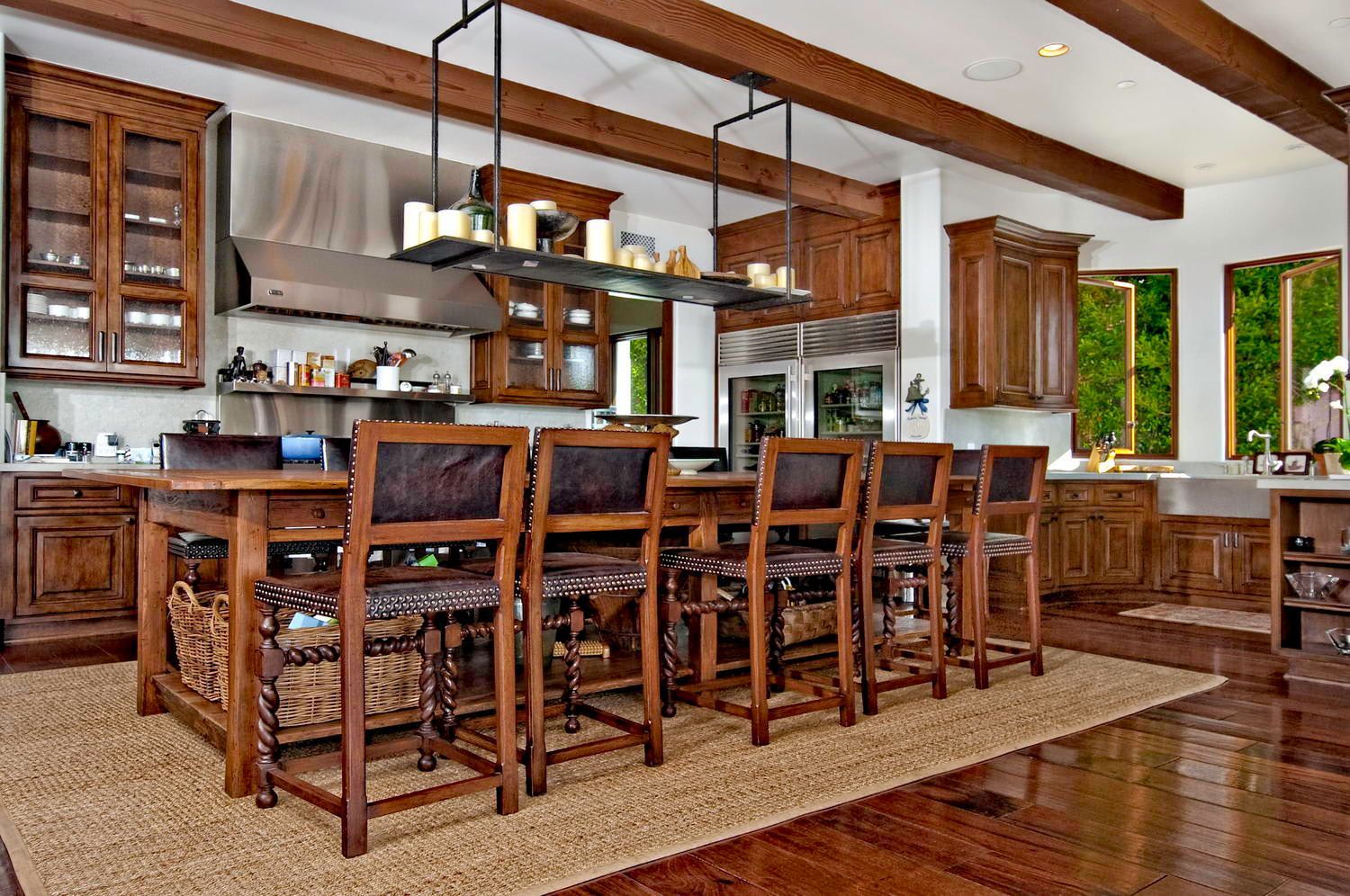 A kitchen with a long table and chairs in it.