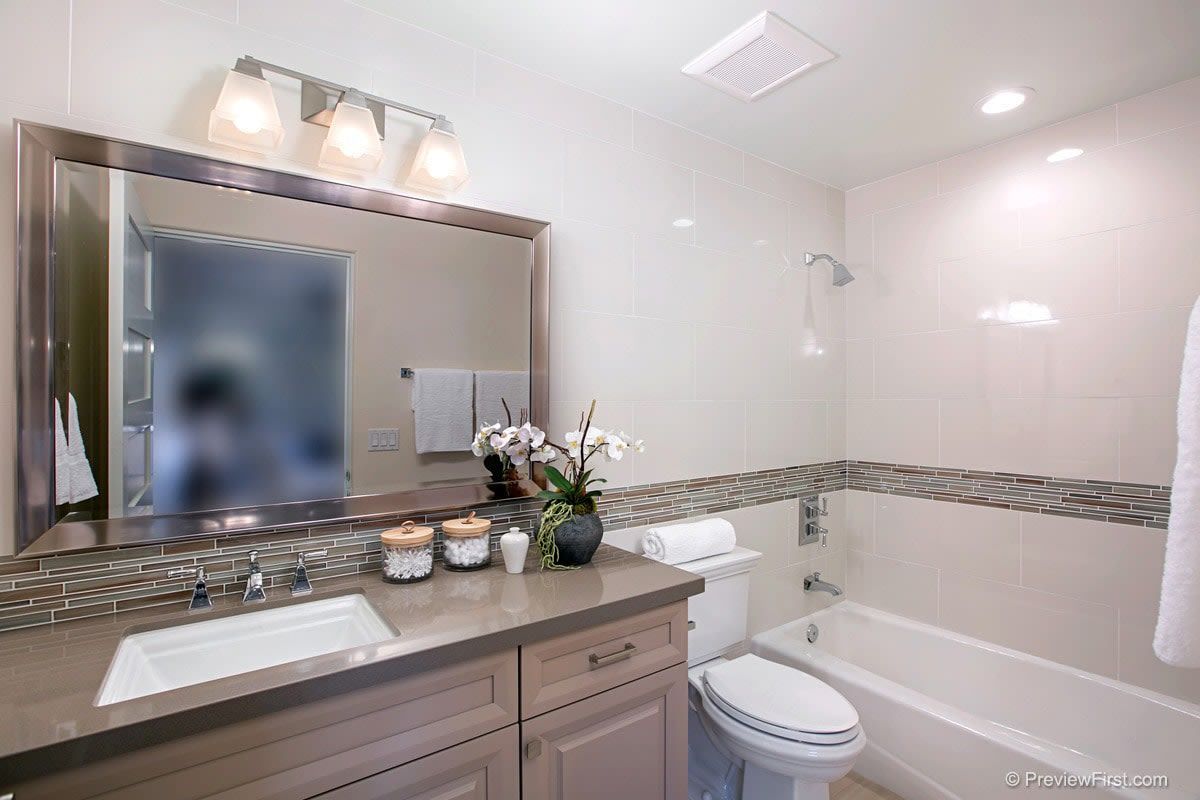 A bathroom with a sink , toilet , tub and mirror.