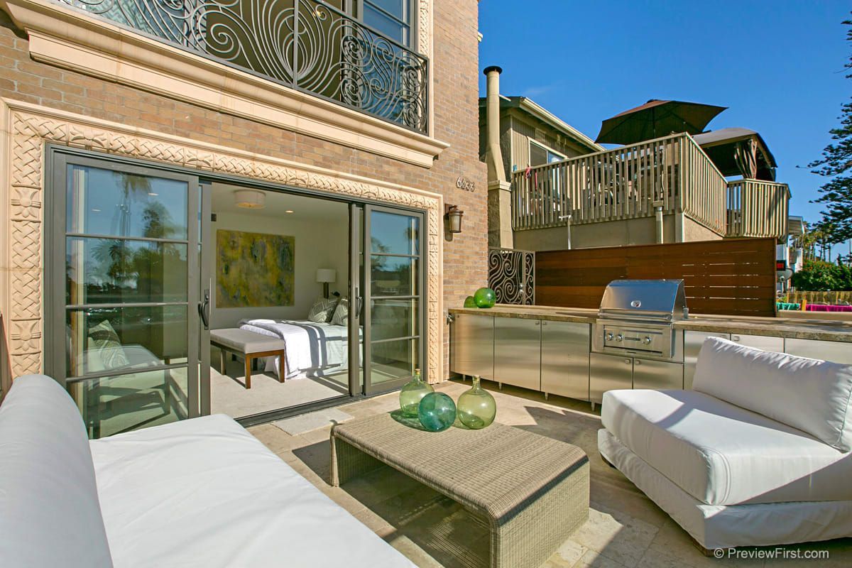 A patio with a couch and a table in front of a house.