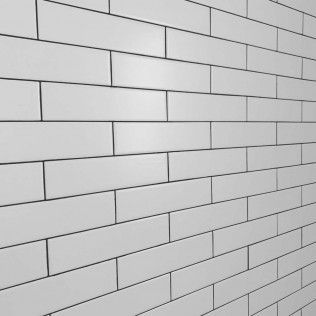 White rectangular tiles with dark grout on a wall, viewed at an angle.