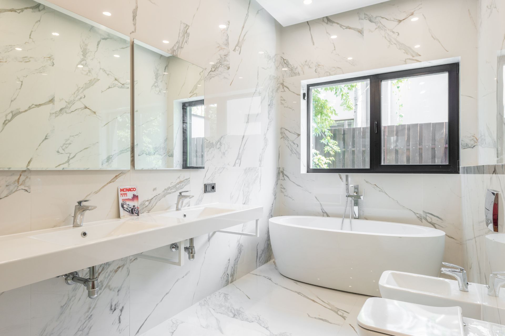 Luxurious white marble bathroom with a soaking tub and double sinks. Plumbing Services in Plymouth