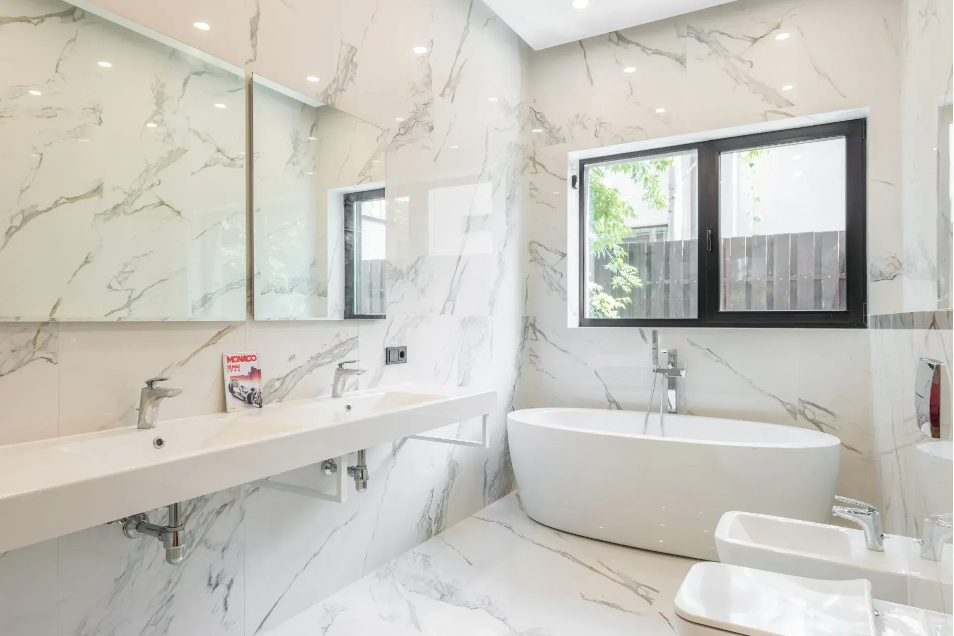 Luxurious white marble bathroom with a soaking tub and double sinks. Plumbing Services in Plymouth