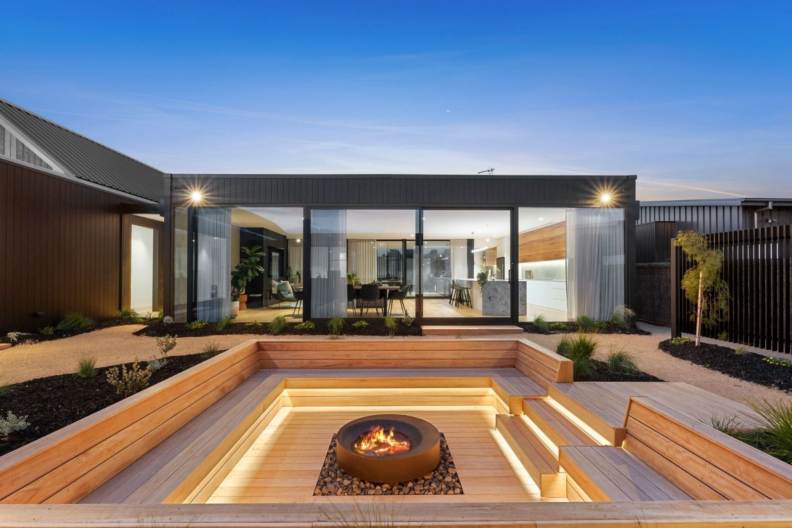 A modern house with a fire pit in front of it.