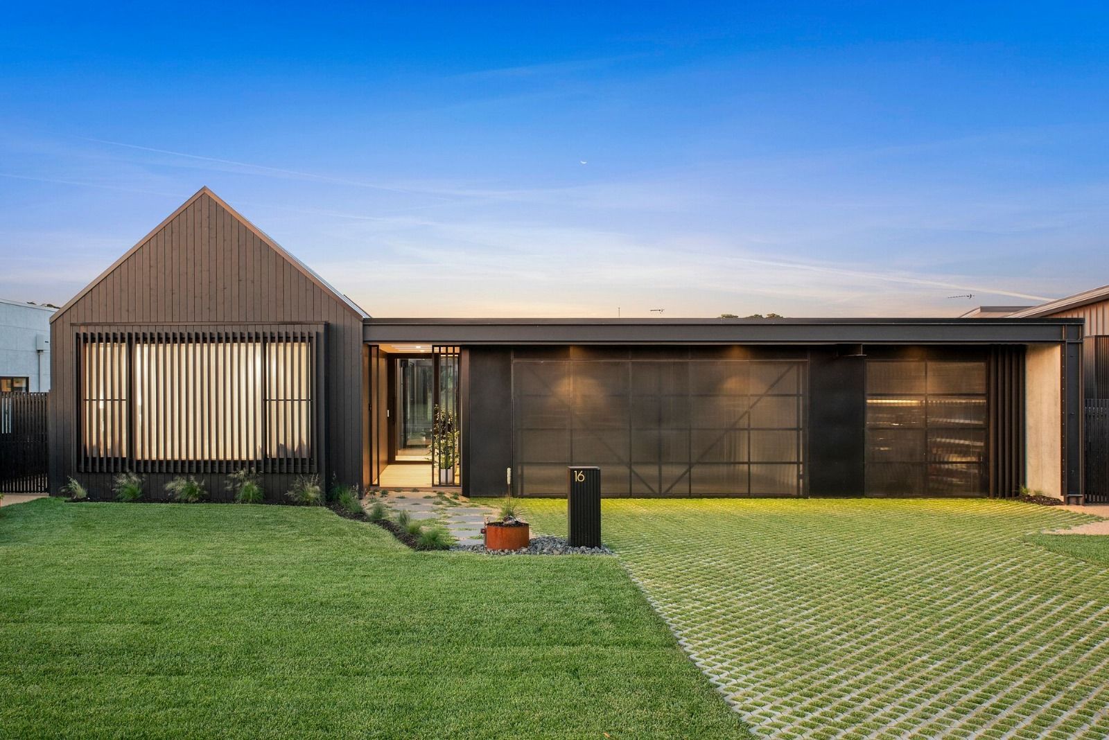 A modern house with a large lawn in front of it.