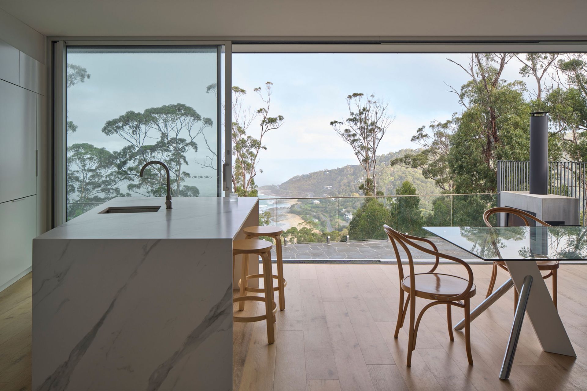 A kitchen with a table and chairs and a view of trees.
