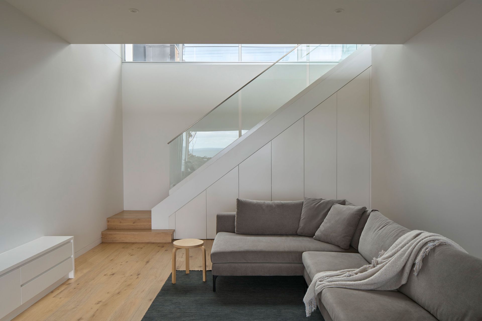 A living room with a couch and stairs in the background