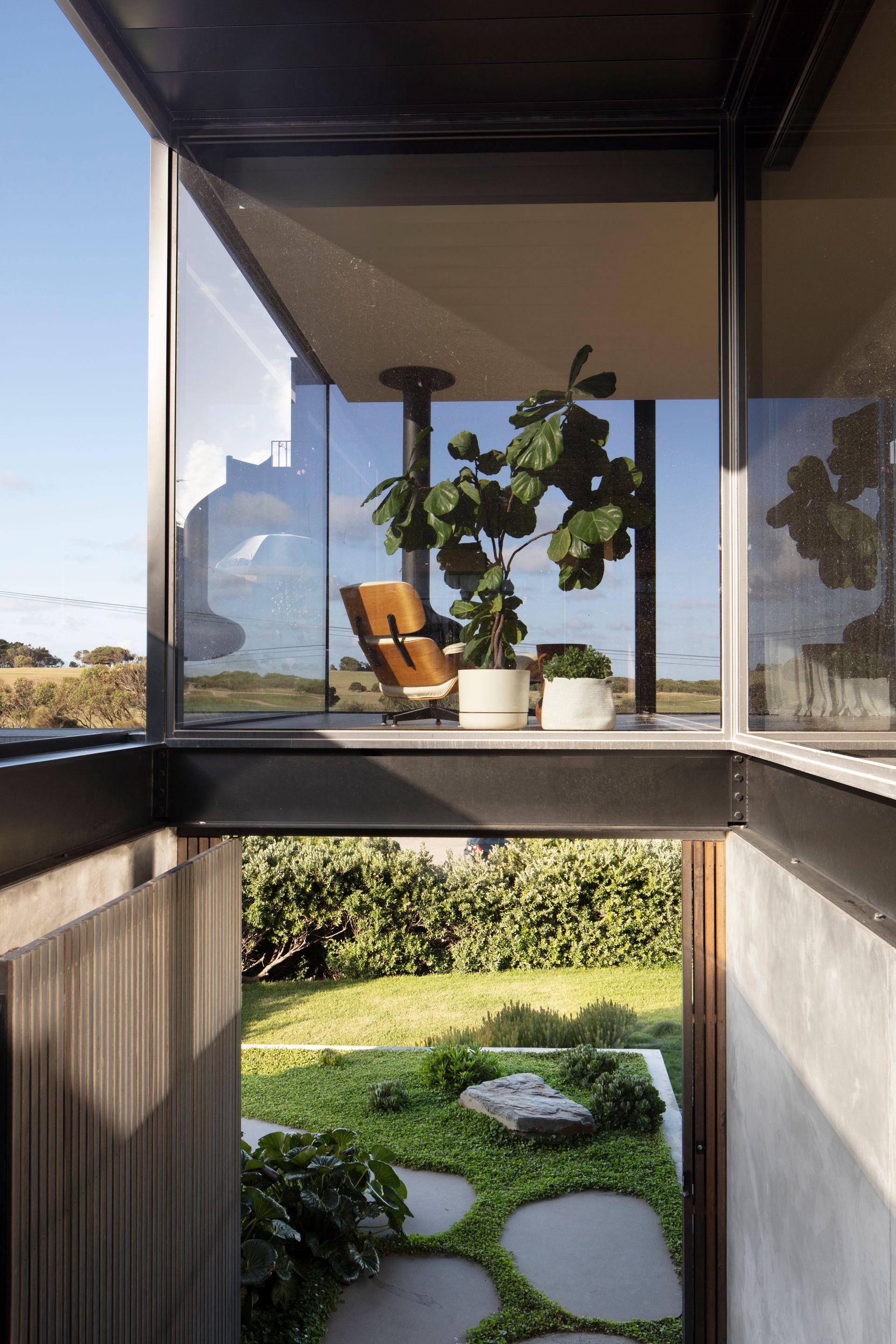 A house with a lot of windows and a chair on the balcony.