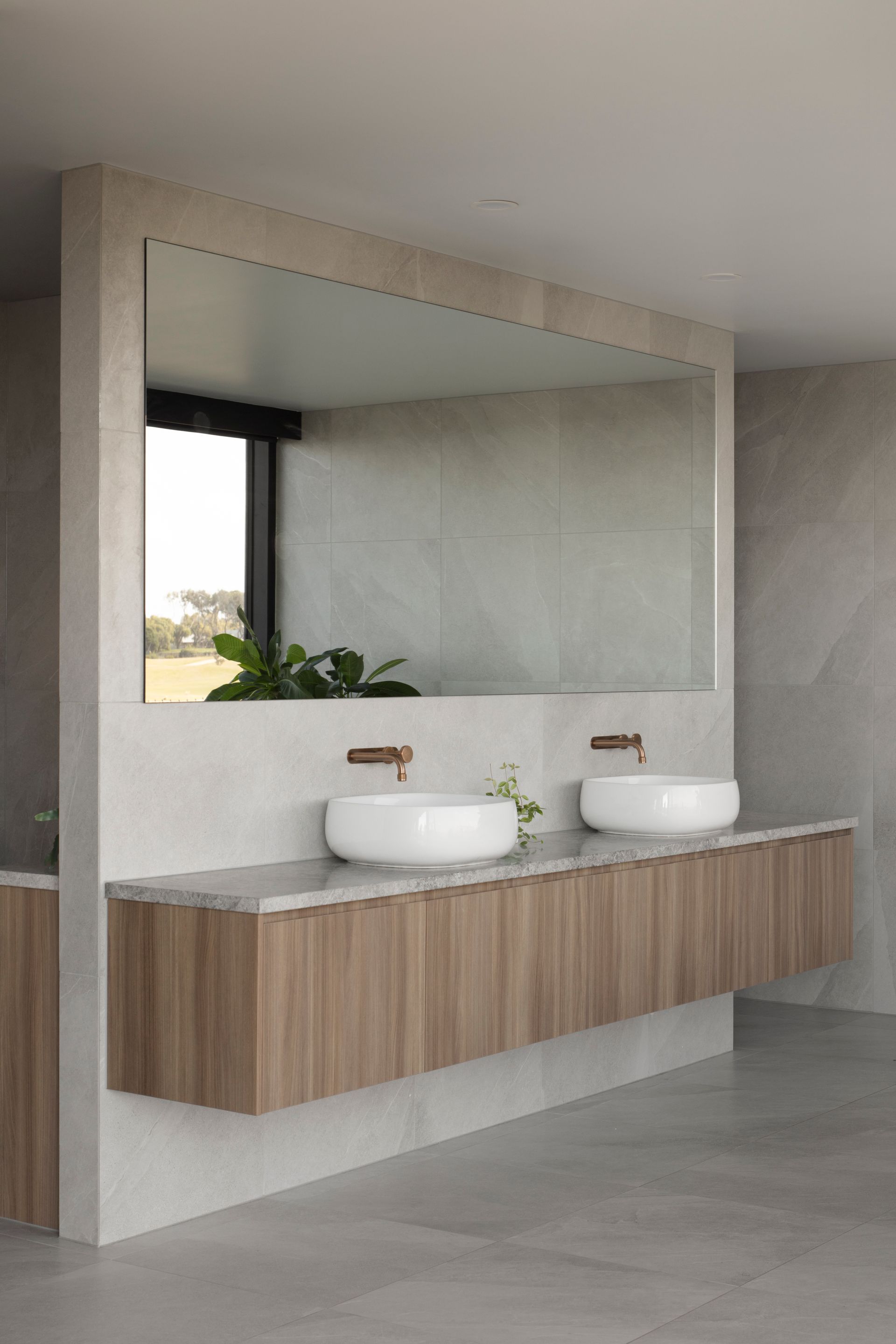 A bathroom with two sinks and a large mirror.