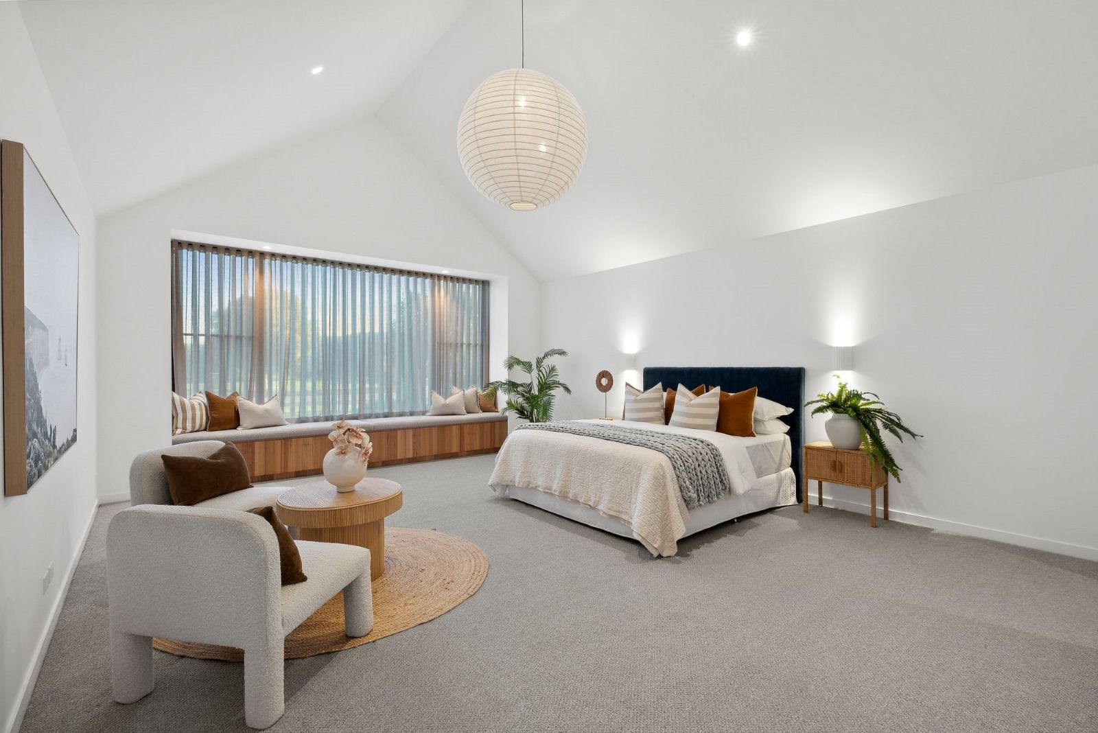 A bedroom with a large bed , chair , table and window.