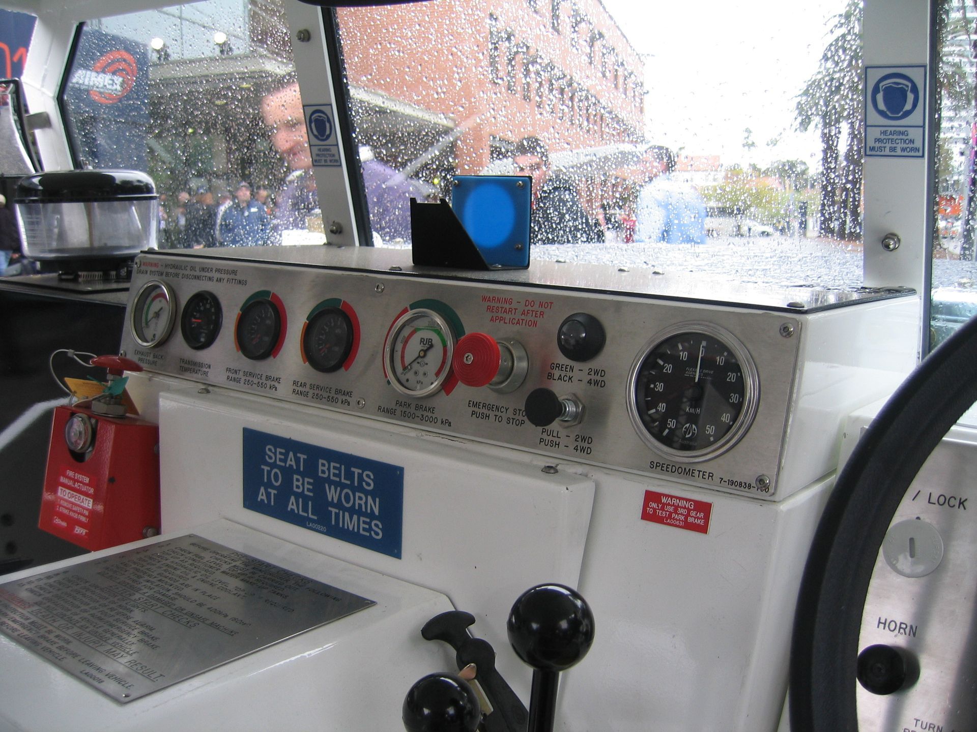 A man is standing behind a machine that is cutting a piece of metal.
