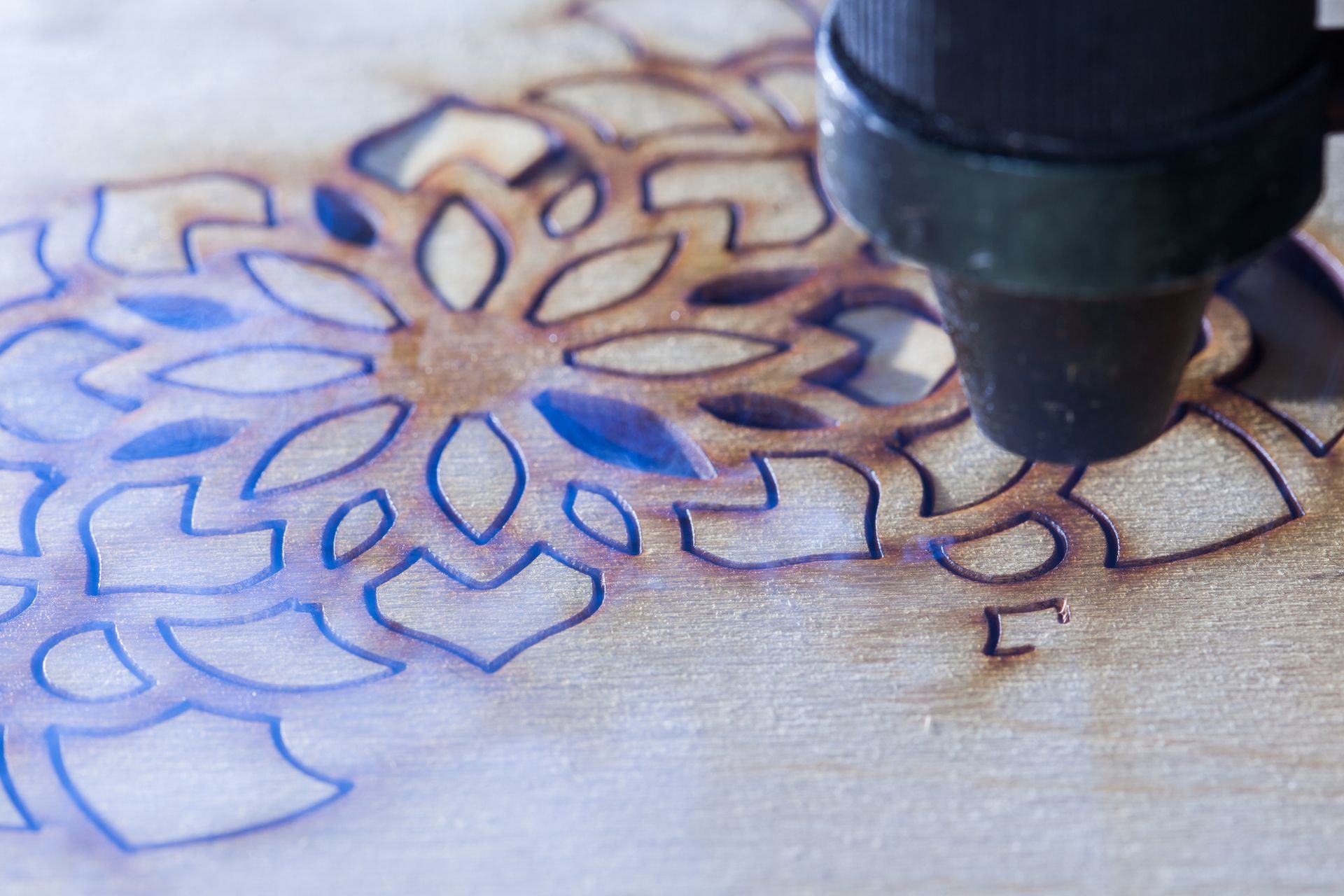 A machine is cutting a pattern on a piece of wood.