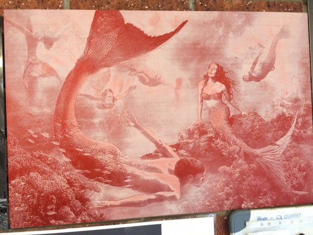 A painting of mermaids on a brick wall