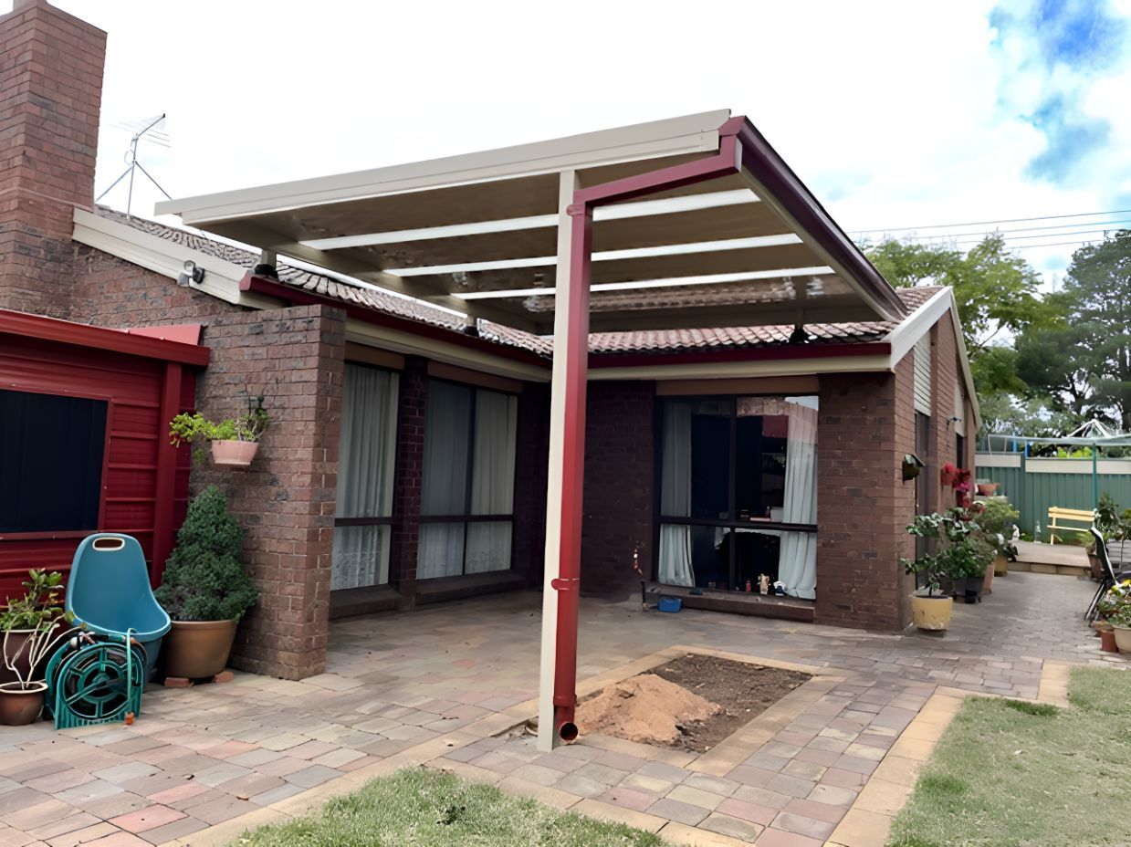 A Brick House With A Patio And A Canopy Over It — All Top Roofing In Gungahlin, ACT