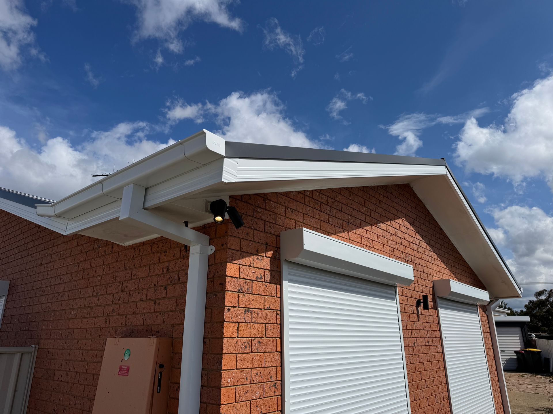 A house with a white gutter and a red brick — All Top Roofing In Gungahlin, ACT