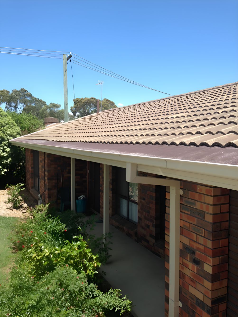 A Brick House With A Tiled Roof And Gutters — All Top Roofing In Royalla, NSW