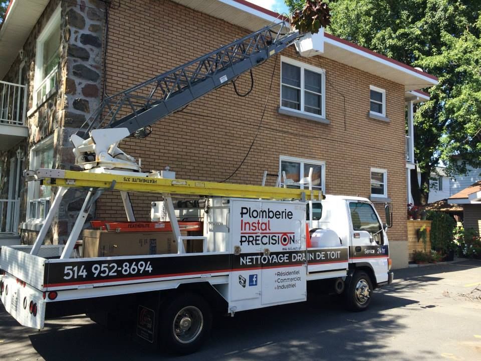 Un camion blanc est garé devant un bâtiment en brique