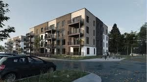 Une voiture est garée devant un grand immeuble.