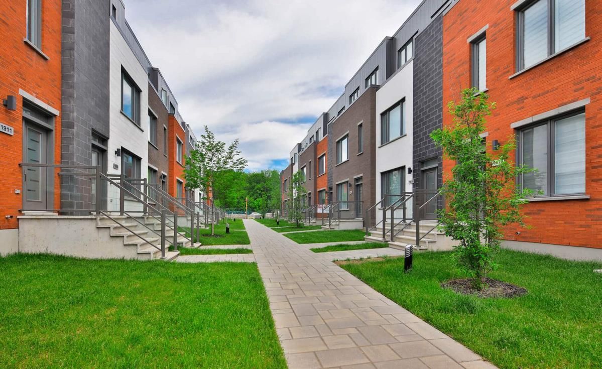 Une rangée d'immeubles d'habitation avec un trottoir entre eux.