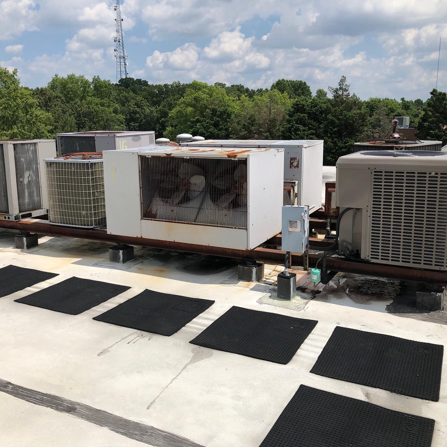 A man is working on an air conditioner outside of a building.
