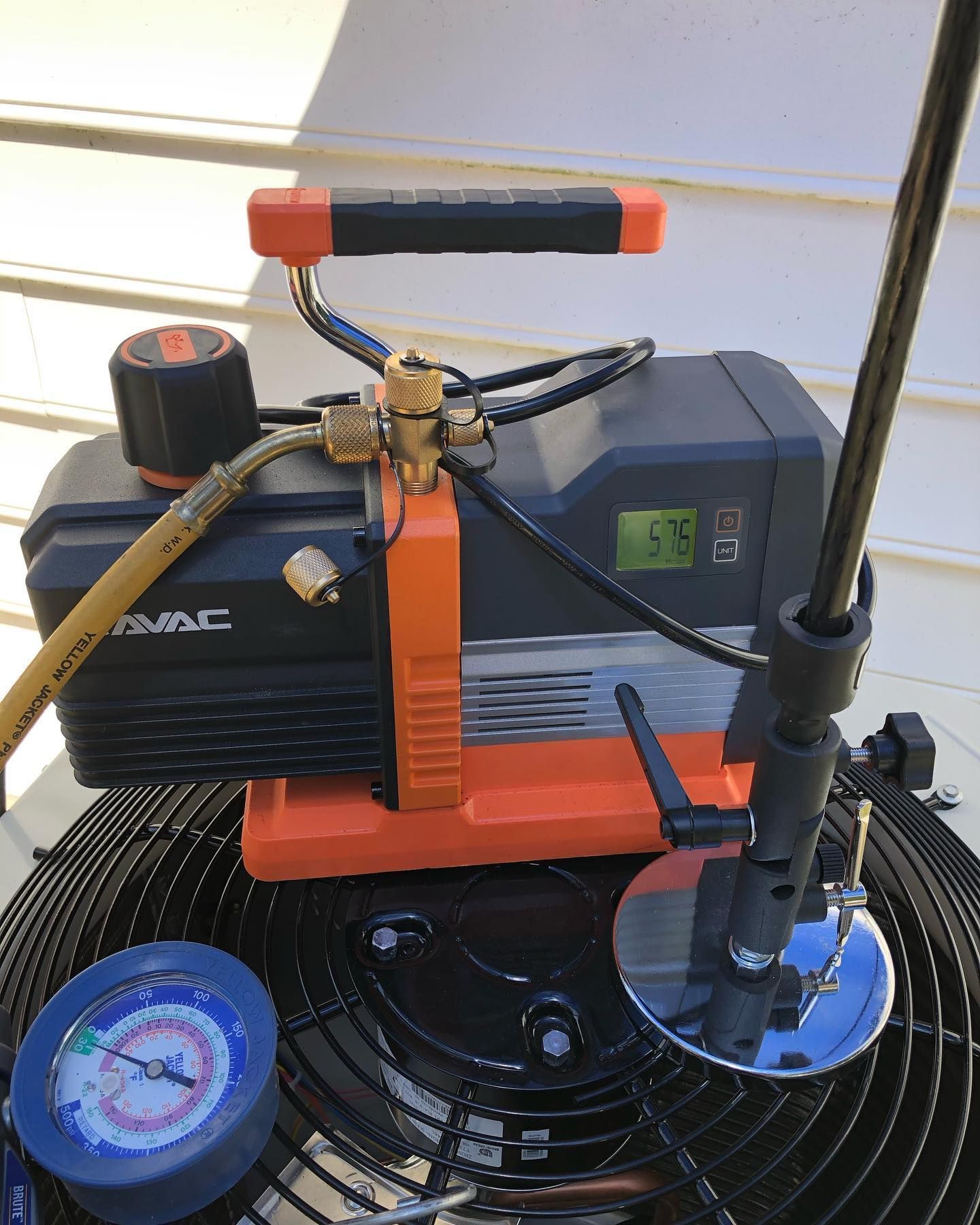 A vacuum pump is sitting on top of an air conditioner.