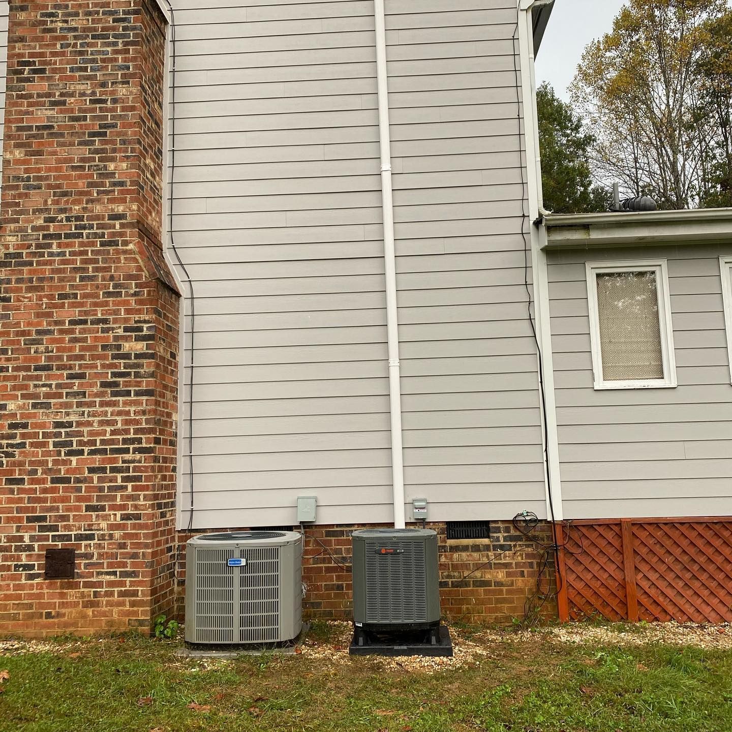 A house with two air conditioners on the side of it.