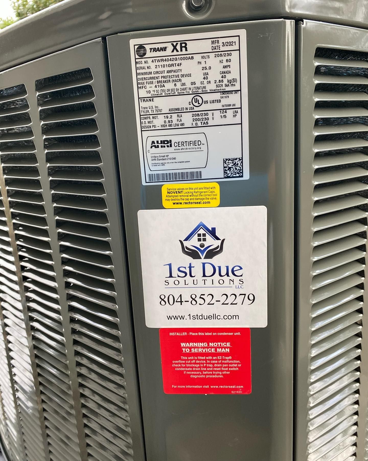 A close up of a gray air conditioner with a sticker on it.