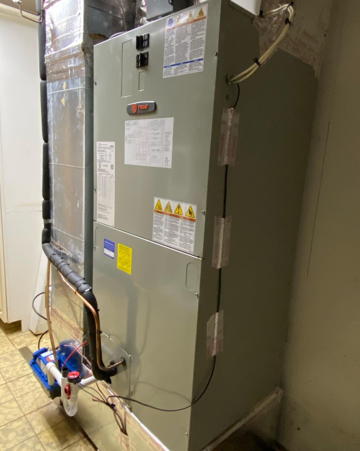 A large heater is sitting in a room next to a wall.