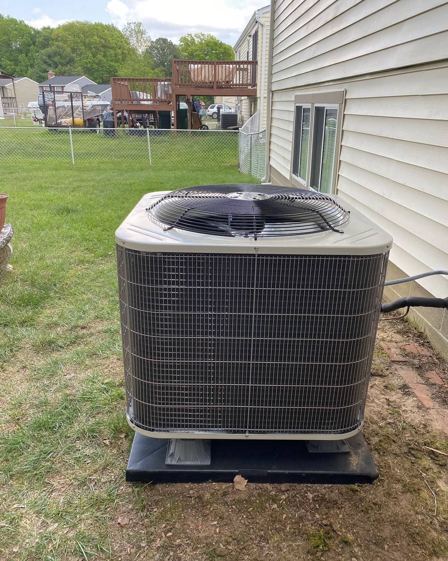 A large air conditioner is sitting on the side of a house.