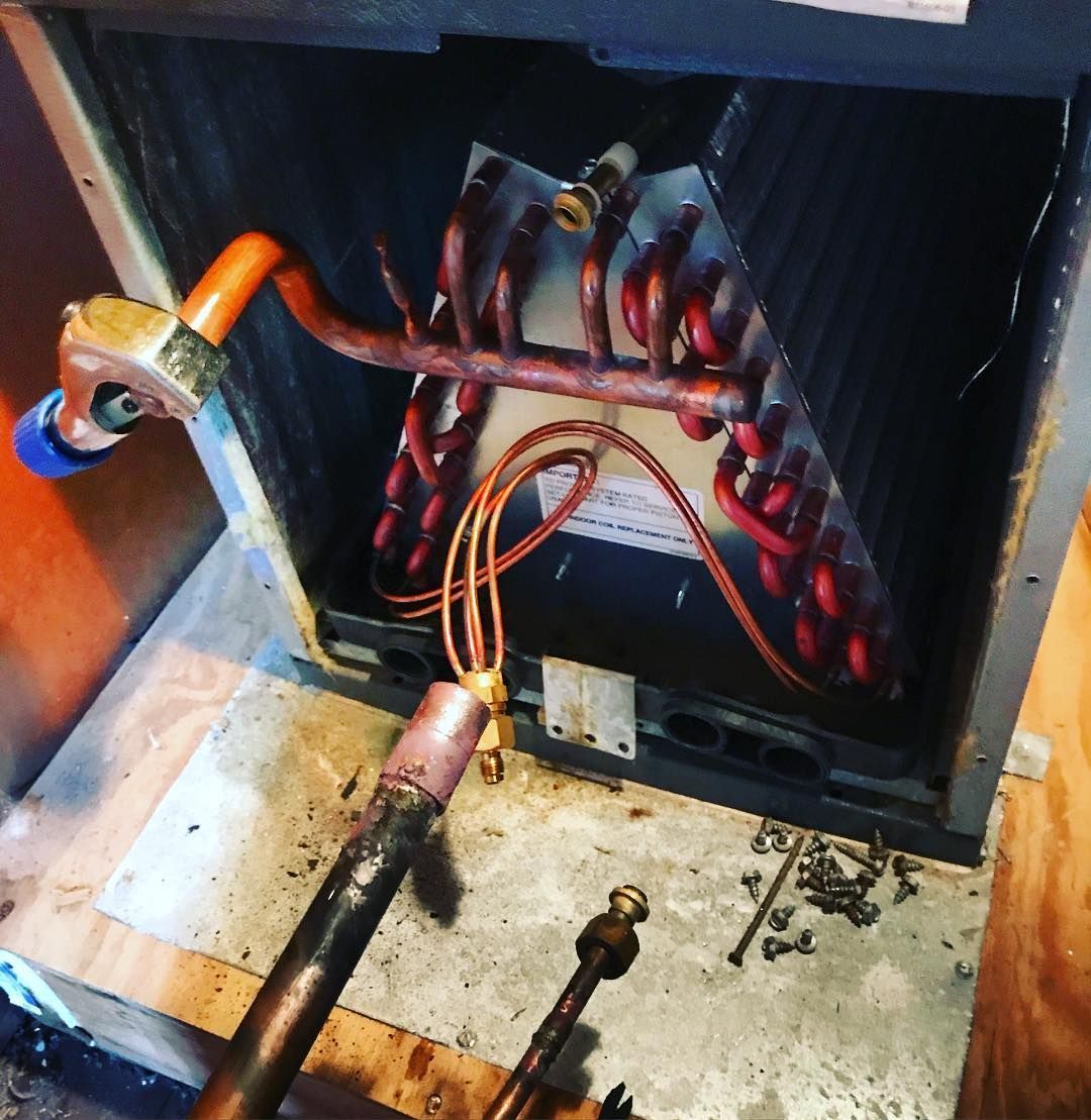 The inside of an air conditioner with copper pipes coming out of it
