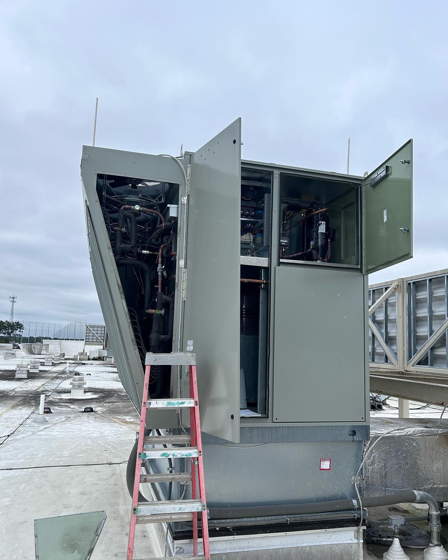 A large building with the door open and a ladder in front of it.