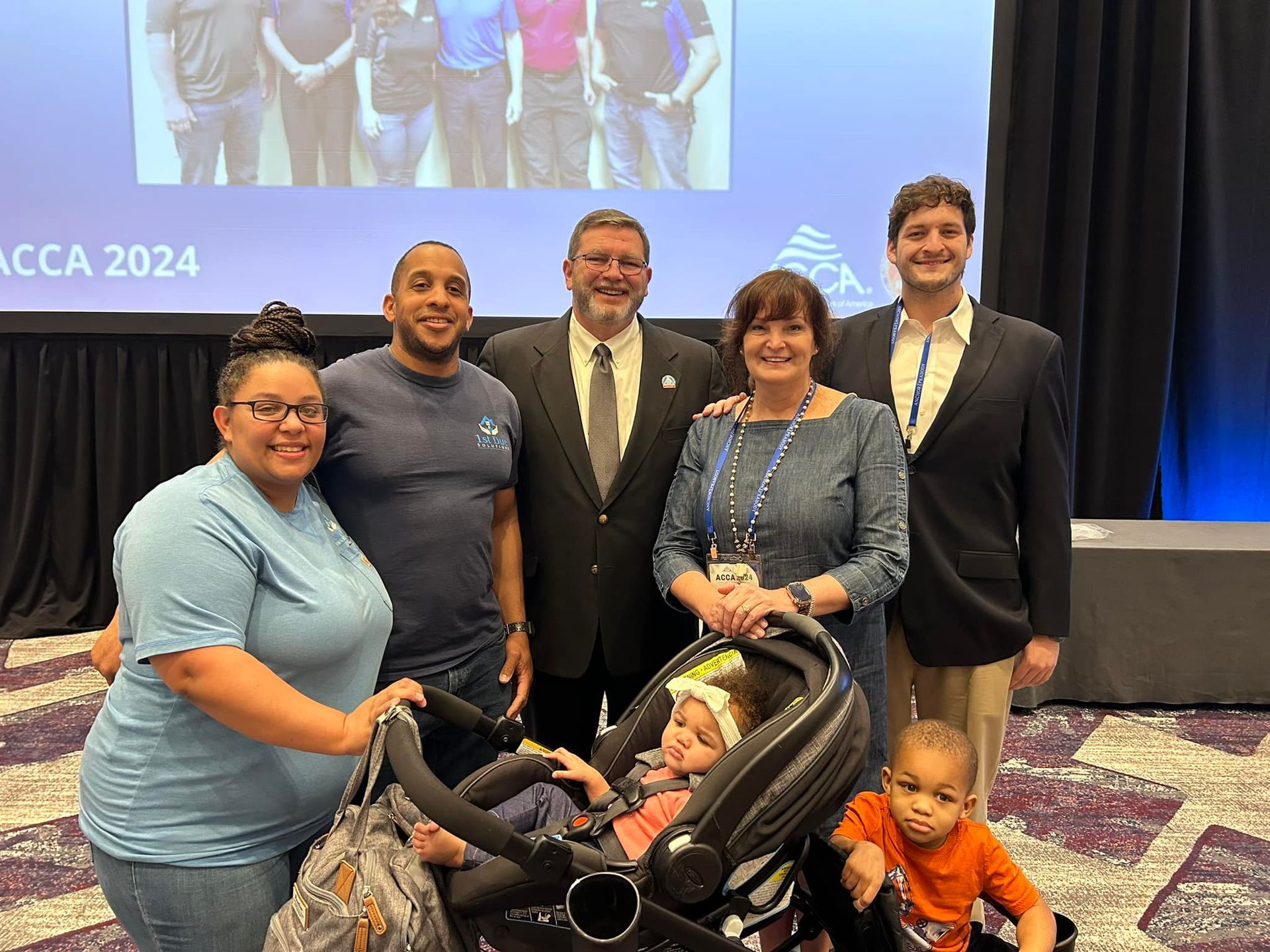 A group of people are posing for a picture with a baby in a stroller.
