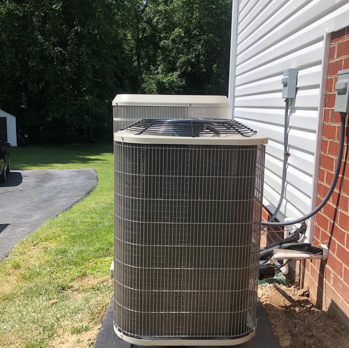 A large air conditioner is sitting on the side of a house.
