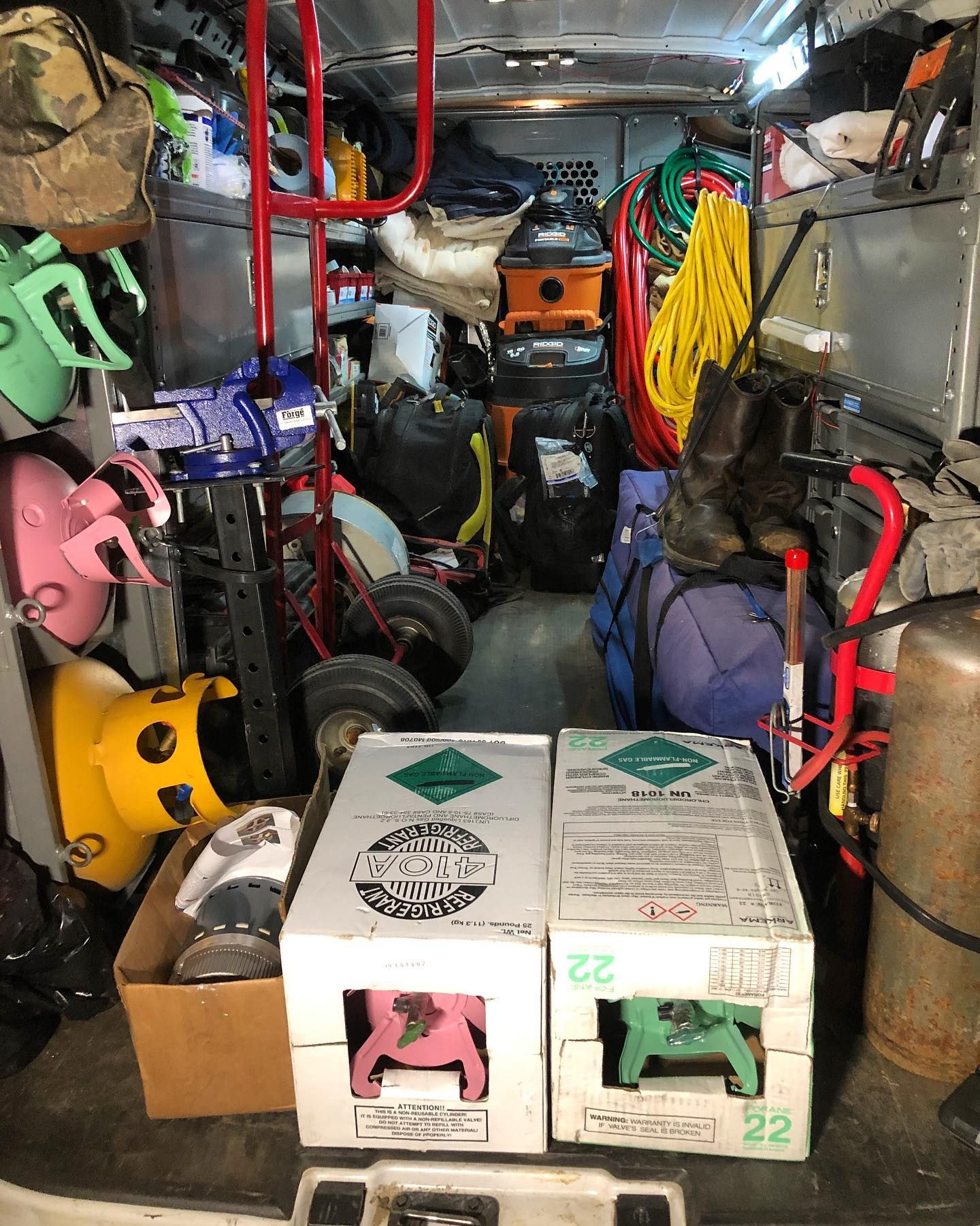 A van is filled with lots of tools and boxes.