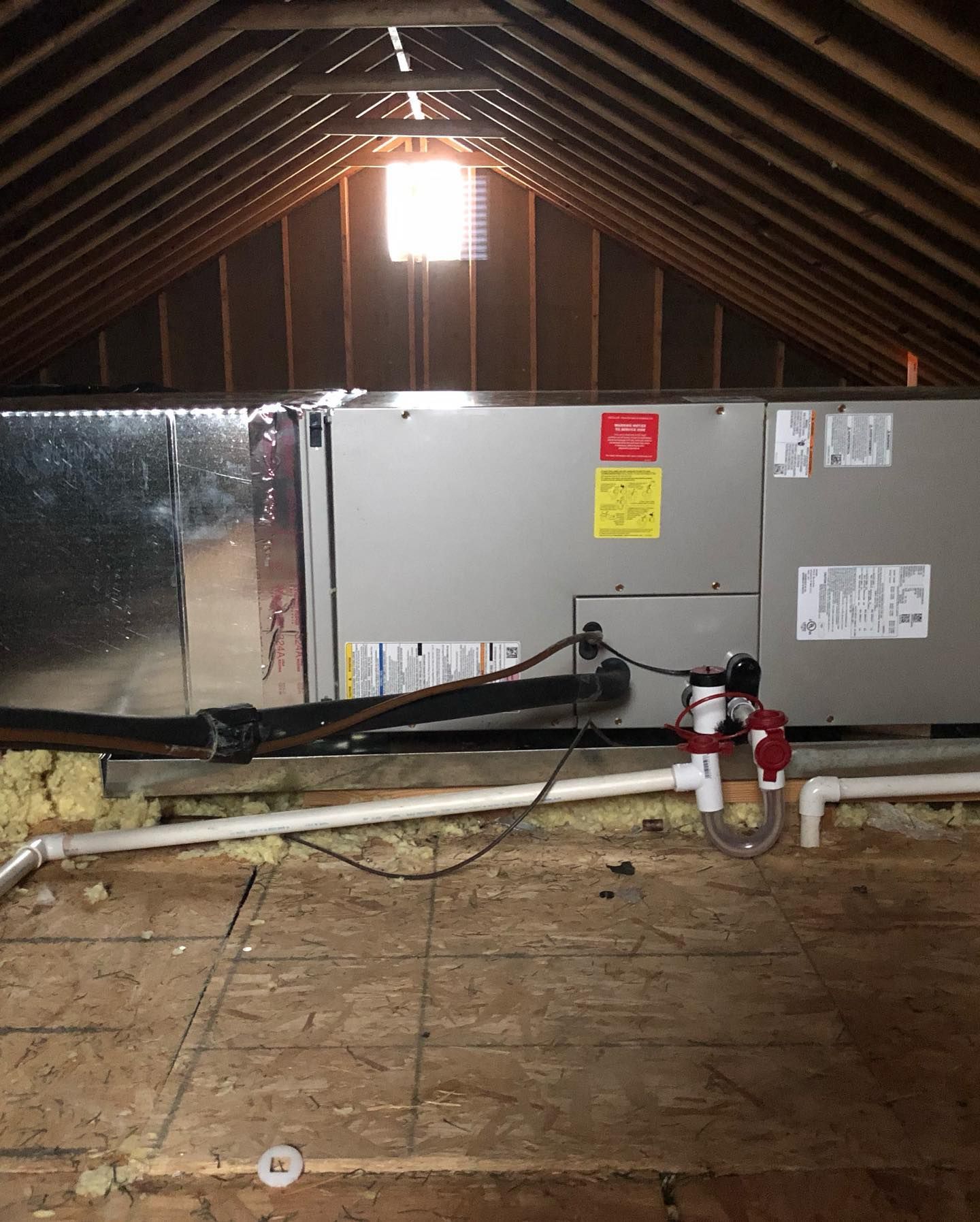 An air conditioner is sitting in the attic of a house