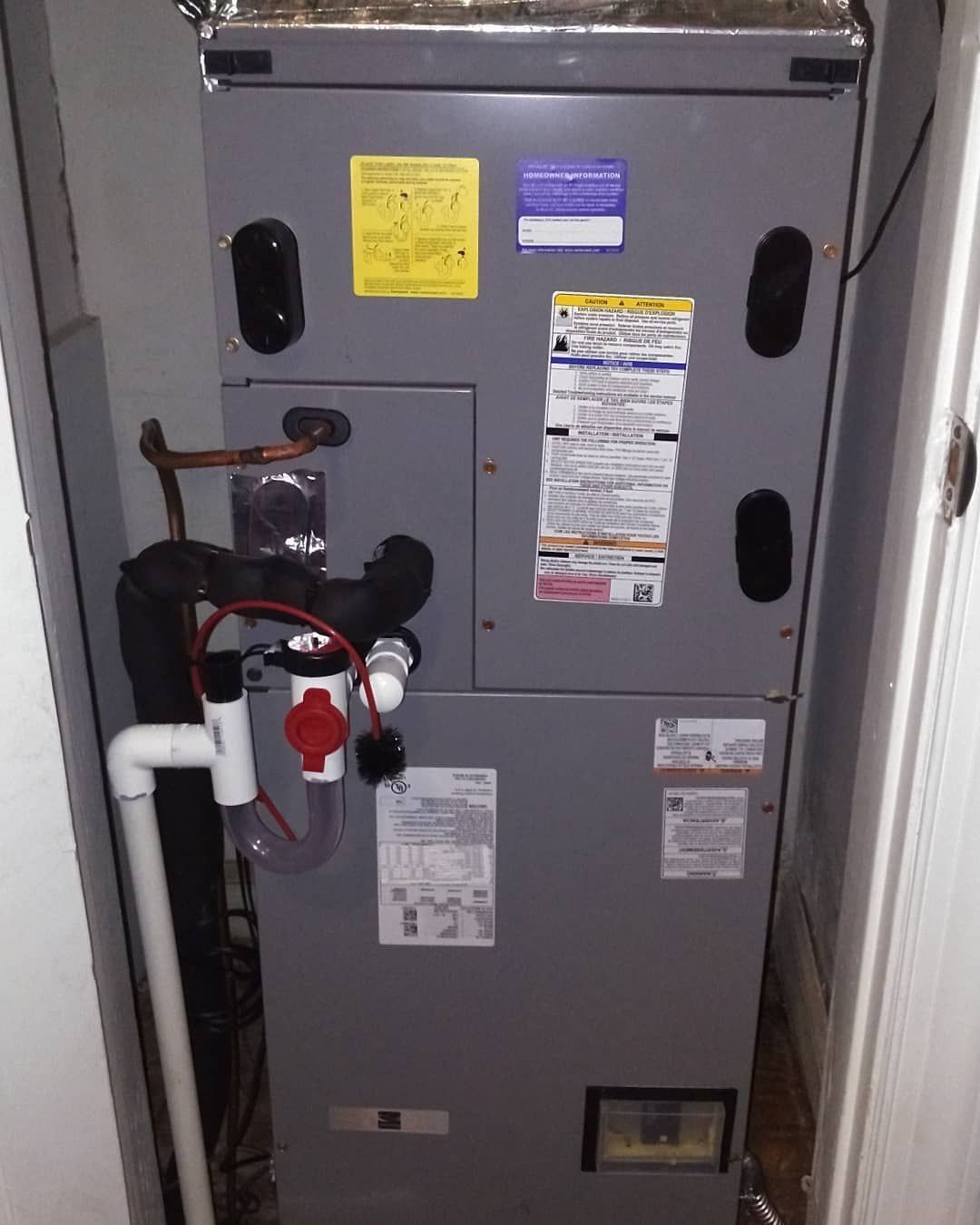 An air conditioner is sitting in a corner of a room