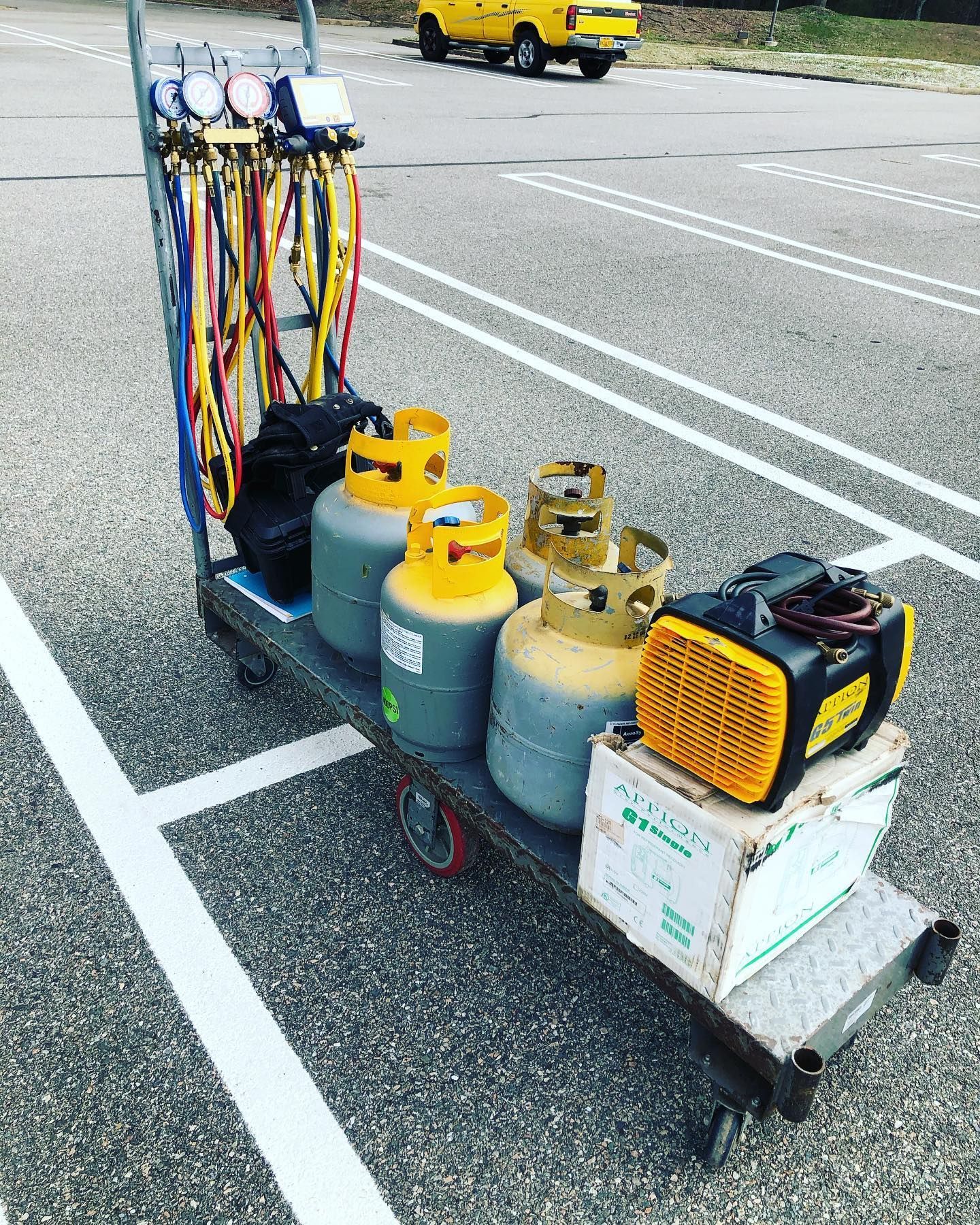 A cart filled with gas cylinders and equipment is parked in a parking lot.