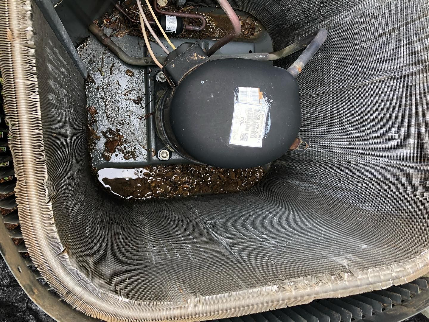 A close up of a dirty air conditioner with a motor inside of it.